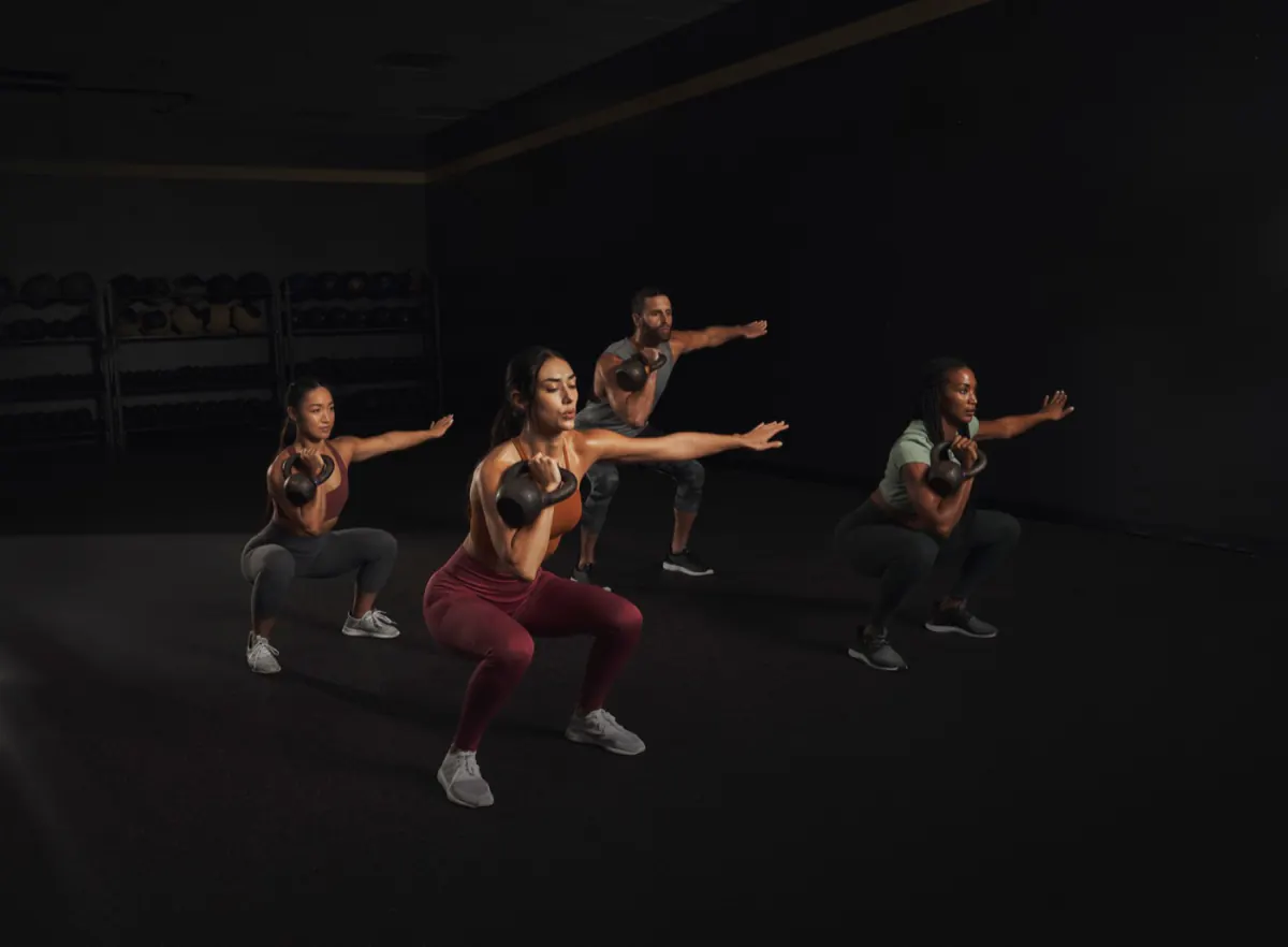 Members performing kettlebell squats together
