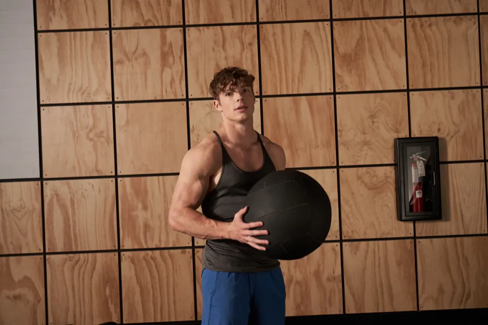 A member holding a medicine ball between sets